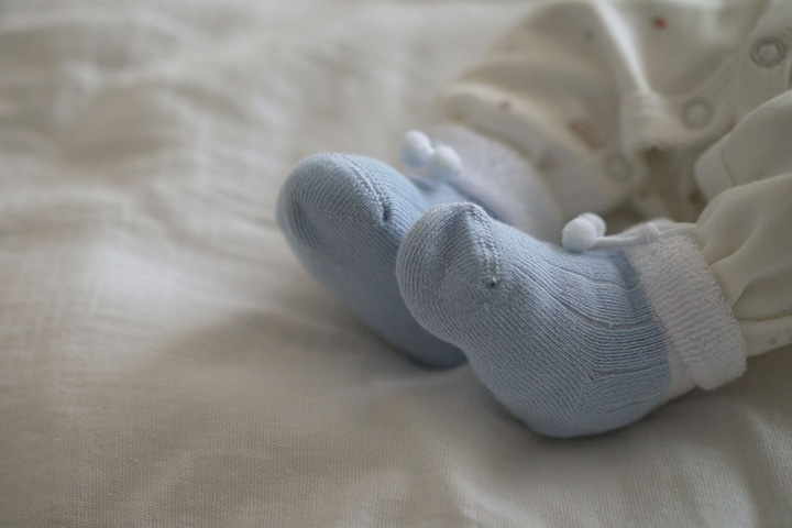 用袜子盖住宝宝的脚，防止软膏摄入