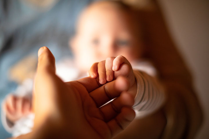 Holding newborn's hands