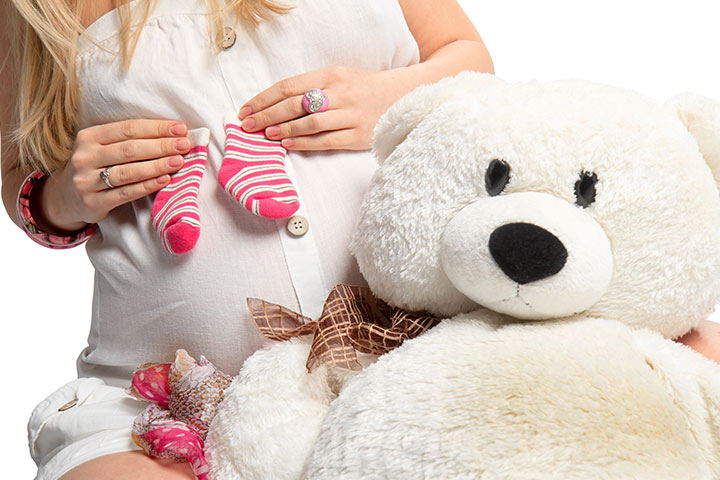 一张带有柔软玩具的孕妇照片