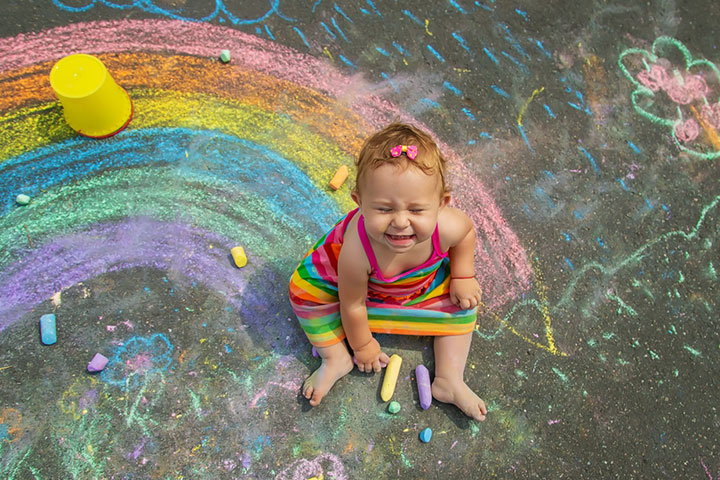 child-draws-chalk-on-asphalt-selective